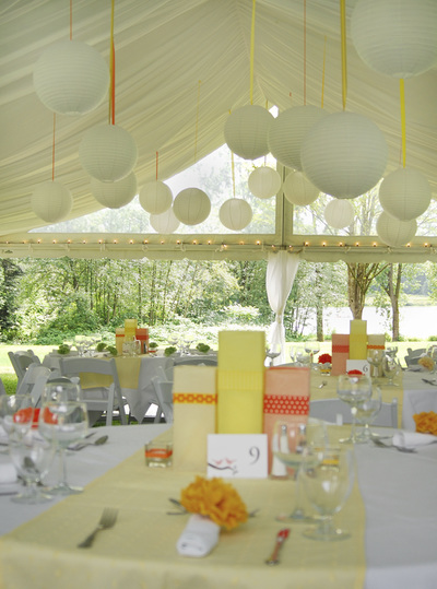 Outdoor catering event under a tent with handing orbs and formal table setting